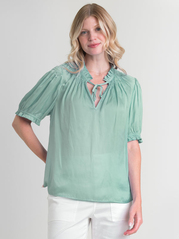 Woman wearing the Smock Neck Blouse by Margaret O'Leary.