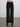 Person wearing the Trish Wide Leg Pant by Margaret O'Leary, a black, high-waisted pant against a plain background.