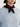 Person wearing a light blue cable knit sweater with a dark burgundy Cashmere Triangle Scarf by Margaret O'Leary around the neck on a white background