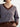 Closeup of a person wearing the Jacquard Vee, a brown and blue patterned sweater by Margaret O'Leary paired with brown pants