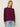 Woman wearing the Mendocino Pullover, a marled pink sweater by Margaret O'Leary, and light blue jeans against a plain background.