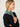 Woman wearing a Cashmere Triangle Scarf by Margaret O'Leary, a green scarf on a plain background.