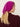 Woman wearing a Cashmere Triangle Scarf by Margaret O'Leary, a magenta headscarf on a plain background.