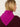 Woman wearing a Cashmere Triangle Scarf by Margaret O'Leary, a magenta scarf on a plain background.