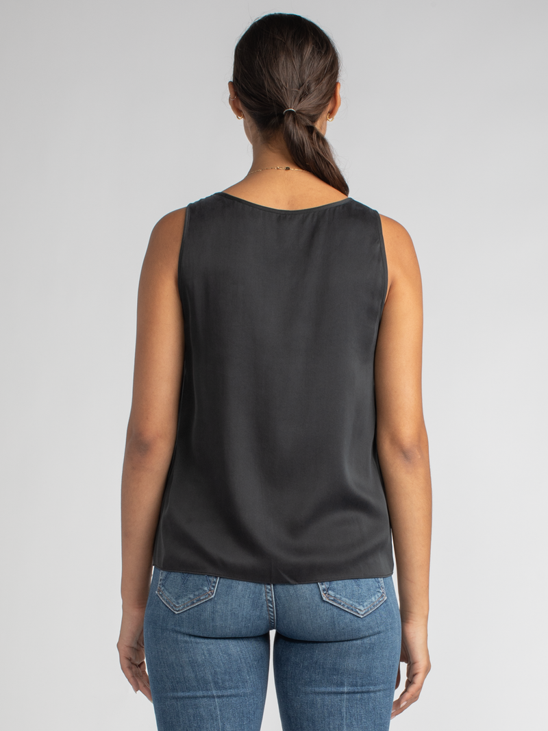 Back view of the model wearing a black tank and a pair of jeans.