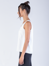 Side view of the model wearing a white silk tank and a black silk skirt.