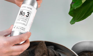 A woman handwashing a cashmere sweater.