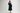Woman wearing a teal velvet midi dress with a chunky navy knit cardigan and black strappy heels.