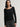 Woman wearing a black Stretch Ballet Tee and grey pants by Margaret O'Leary against a plain background