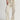Person wearing parchment Sadie Pants with a matching belt by Margaret O'Leary on a plain background