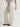 Person wearing parchment Sadie Pants with a matching belt by Margaret O'Leary on a plain background