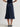 Person wearing a Navy blue Sandra Skirt with a matching belt by Margaret O'Leary on a plain background
