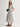 Woman wearing a white and grey pinstripe Tiered VNeck Dress by Margaret O'Leary on a white background