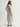 Woman wearing a white and grey pinstripe Tiered VNeck Dress by Margaret O'Leary on a white background