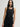 Woman wearing a black Stretch Scoop Tank and black pants by Margaret O'Leary against a plain background