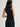 Woman wearing a black Stretch Scoop Tank and black pants by Margaret O'Leary against a plain background