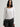 Woman wearing a white Stretch Ballet Tee and grey pants by Margaret O'Leary against a plain background
