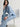 Woman wearing a blue button down Drapey Twill Shirt and matching Drapey Twill Pant by Margaret O'Leary against a grey backdrop.