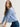 Woman wearing a cashmere-silk Coco cardigan by Margaret O'Leary and dark blue jeans on a plain background
