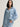 Woman wearing a blue button down Drapey Twill Shirt and matching Drapey Twill Pant by Margaret O'Leary against a grey backdrop.