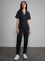 Female model wearing black jumpsuit with belt.