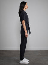 Female model wearing black jumpsuit with belt.