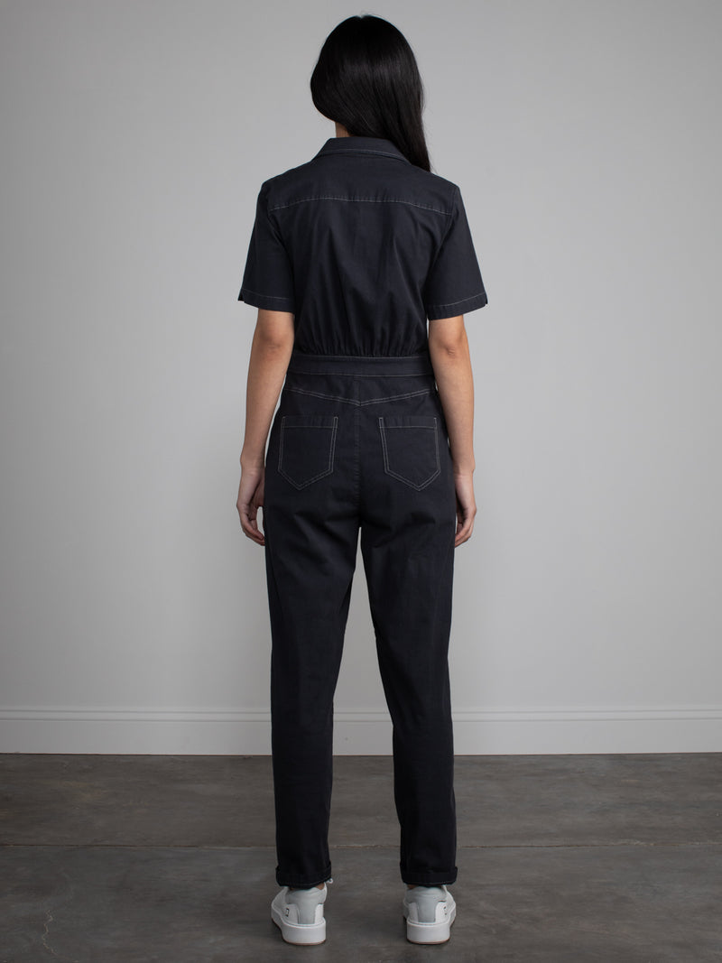 Female model wearing black jumpsuit with belt.