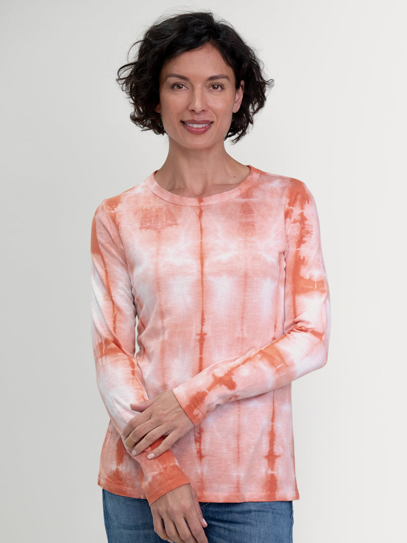 Woman wearing a peach tie dye long sleeve tee by Margaret O'Leary.