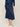 Woman wearing a navy satin cinched Clementine Skirt and matching boucle Colette Crew Cardigan by Margaret O'Leary.