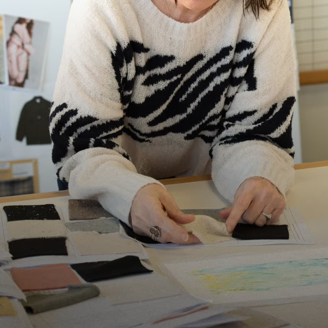 Woman comparing textiles on table.