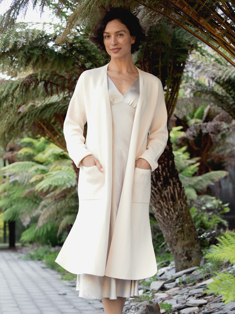 Woman wearing the Midi Belted Coat in Ivory by Margaret O'Leary.
