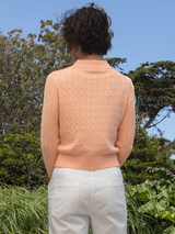 Woman wearing the Emmylou Cable Cardi in apricot by Margaret O'Leary.