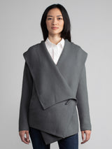 Female wearing grey hooded shawl.