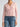Person wearing a light pink Cashmere Vee Cardigan by Margaret O'Leary and blue jeans on a plain background