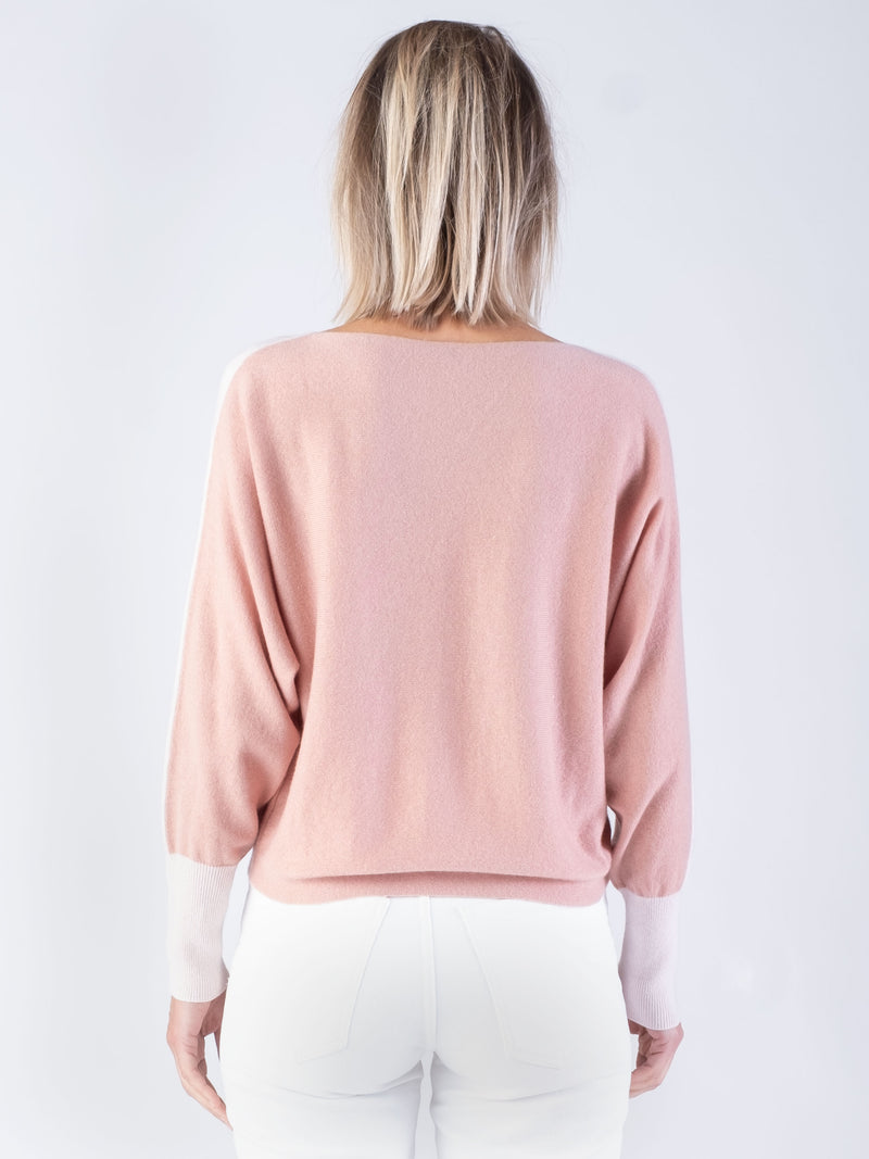 Woman wearing a pink and green cashmere sweater.