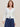 Woman wearing a white boucle Ruffle Cardigan over a navy cotton skirt by Margaret O'Leary