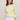 Woman wearing a light yellow cotton boucle Lolita Pullover by Margaret O'Leary against a plain background
