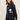 Person wearing a black Rose Duster by Margaret O'Leary with a white rose design against a beige background