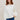 Woman wearing a cotton Milk Lola Pullover by Margaret O'Leary against a beige background