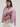 Woman wearing a cashmere-silk Coco cardigan by Margaret O'Leary and dark blue jeans on a plain background