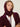 Woman wearing a Cashmere Snood by Margaret O’Leary, a burgundy hooded snood with drawstrings styled with a burgundy knit cardigan.