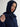 Woman wearing a Cashmere Snood by Margaret O’Leary, a navy hooded snood with drawstrings styled with a navy cable knit zip cardigan.
