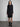Female model wearing midi black dress with long sleeves. 