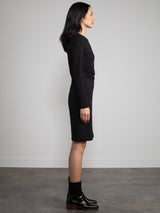 Female model wearing midi black dress with long sleeves. 