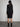 Female model wearing midi black dress with long sleeves. 