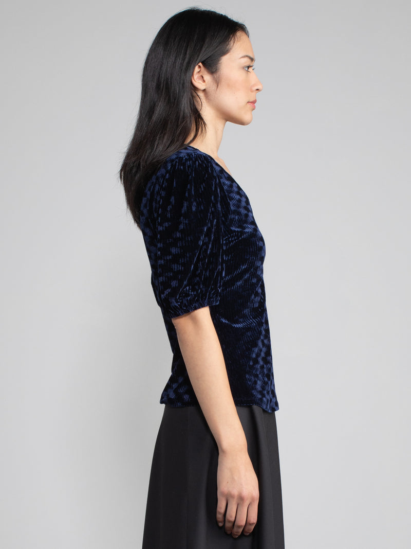Woman wearing blue velvet blouse with corduroy effect. 