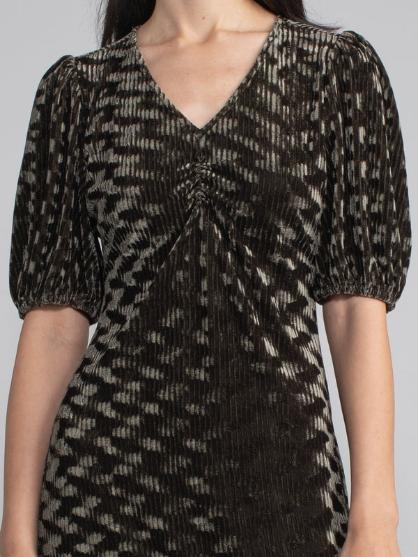 Woman wearing green velvet midi dress with corduroy effect. 