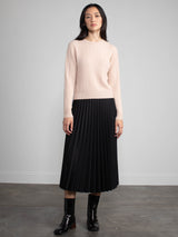 Woman wearing a black pleated skirt.