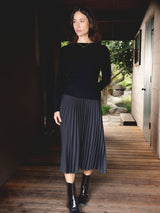 Woman wearing a black pleated skirt.