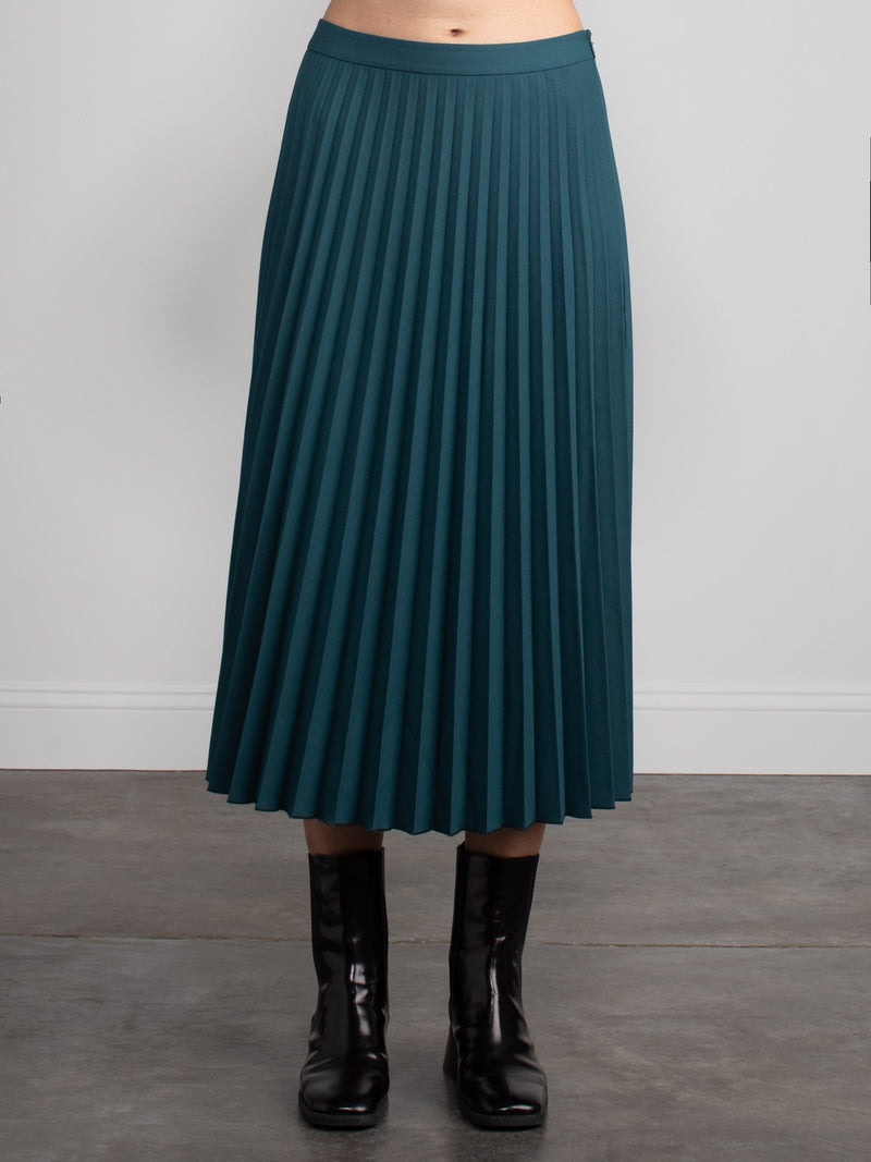 Woman wearing a green pleated skirt.